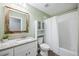 Bathroom with white vanity, white-tiled shower, toilet, mirror and green paint at 5320 Karr Rd, Cumming, GA 30040