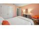 Bedroom features salmon-colored walls, white double-door closet and white bedding with orange accents at 5320 Karr Rd, Cumming, GA 30040