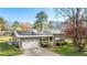 Charming home with solar panels, a metal roof, a garage, landscaping, and a spacious front yard at 5320 Karr Rd, Cumming, GA 30040