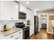 Modern kitchen with white cabinets, granite counters, and sleek black appliances at 5320 Karr Rd, Cumming, GA 30040
