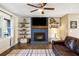 Cozy living room featuring a blue brick fireplace, wood-look tile flooring, and floating shelves at 5320 Karr Rd, Cumming, GA 30040