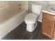 Bathroom features a tub-shower combo, toilet, wood vanity, and modern wood-look flooring at 5626 Pine Gate Dr, Atlanta, GA 30349