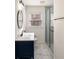 Modern bathroom features a navy blue vanity, walk-in shower with glass door, and hexagon tile flooring at 1140 Goodwin Ne Pl, Atlanta, GA 30319