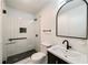 Modern bathroom with tiled glass shower, black fixtures, and stone-topped vanity at 1140 Goodwin Ne Pl, Atlanta, GA 30319