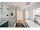 A contemporary bathroom design featuring black and white tile, a glass shower enclosure, and a soaking tub at 1140 Goodwin Ne Pl, Atlanta, GA 30319