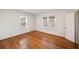 Bright bedroom with hardwood floors, white walls, two windows, and a door to the hallway at 1140 Goodwin Ne Pl, Atlanta, GA 30319