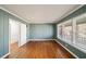 Bright bedroom with blue wood paneled walls, hardwood flooring, large windows, and white trim at 1140 Goodwin Ne Pl, Atlanta, GA 30319