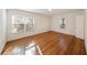 Sunlit bedroom featuring hardwood flooring, white walls, two windows with blinds, and a white door at 1140 Goodwin Ne Pl, Atlanta, GA 30319