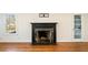 Close-up of the fireplace with a black mantel and hearth, complemented by hardwood flooring at 1140 Goodwin Ne Pl, Atlanta, GA 30319