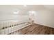 Hallway with white banister and light hardwood floors leading to an upstairs room with dormer window at 1140 Goodwin Ne Pl, Atlanta, GA 30319