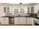 Well-lit kitchen featuring white cabinets, stainless steel appliances, herringbone backsplash, and dark countertops at 1140 Goodwin Ne Pl, Atlanta, GA 30319