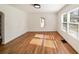 Living room featuring hardwood floors, white walls, large windows, and an archway to another room at 1140 Goodwin Ne Pl, Atlanta, GA 30319
