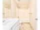 A clean bathroom with a shower-tub combo, white vanity with sink, tile floors, and white walls at 3510 Long Lake Dr, Douglasville, GA 30135
