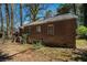 View of the rear exterior of brick home, showcasing the backyard and foundation at 1833 Ridgeland Dr, Decatur, GA 30032