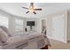 Relaxing bedroom with ceiling fan, carpet floors, neutral tones, and natural lighting at 5910 Roxboro Ct, Cumming, GA 30040