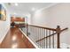 Second story hallway with hardwood floors leading to office space with custom cabinets at 5910 Roxboro Ct, Cumming, GA 30040