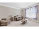 Comfortable living room with neutral walls, plush carpeting, and elegant furnishings illuminated by natural light at 5910 Roxboro Ct, Cumming, GA 30040