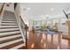 Open-concept living room with hardwood floors and a staircase with railing at 5910 Roxboro Ct, Cumming, GA 30040