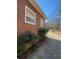 Side view of a property showing the exterior wall and greenery next to the driveway at 1033 Mclendon Dr, Decatur, GA 30033