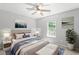 Stylishly staged bedroom boasting a plush bed, tasteful artwork, a ceiling fan, and a sunlit window at 162 Springbottom Dr, Lawrenceville, GA 30046