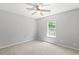 Neutral bedroom featuring a ceiling fan, natural light from a window, and a carpeted floor at 162 Springbottom Dr, Lawrenceville, GA 30046