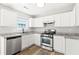 Modern kitchen featuring stainless steel appliances, light-colored countertops, and ample cabinet space for storage at 162 Springbottom Dr, Lawrenceville, GA 30046