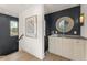 Hallway featuring a wet bar with a modern mirror and stylish fixtures, accented by a striking dark blue wall at 380 2Nd St, Fayetteville, GA 30214