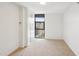 Bright bedroom featuring neutral carpet, white walls, and a large window with city views at 620 Peachtree Ne St # 1806, Atlanta, GA 30308