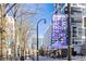 A street view showcasing a 'MidtownATL' banner, street lights, and buildings with trees in the foreground at 620 Peachtree Ne St # 1806, Atlanta, GA 30308