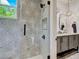 Well-lit bathroom with a glass enclosed shower featuring geometric tile, stylish vanity, and a unique mirror at 650 Jones Rd, Roswell, GA 30075