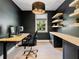 Contemporary home office with floating shelves, wood floors, large window, and a black desk at 650 Jones Rd, Roswell, GA 30075