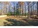 Large fenced backyard featuring grass, mature trees, and new wood fence at 175 Jayne Ellen Way, Alpharetta, GA 30009