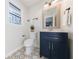 Charming bathroom featuring a blue vanity, patterned tile floor, and window views at 175 Jayne Ellen Way, Alpharetta, GA 30009