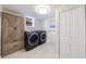 Well-lit laundry room with modern washer and dryer, built-in cabinets, and tile flooring at 175 Jayne Ellen Way, Alpharetta, GA 30009