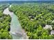 Aerial view of lush green landscaping with a winding river and a collection of beautiful homes at 510 Covington Cv, Alpharetta, GA 30022