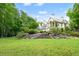 Beautiful backyard featuring stone steps leading to an elegant home with lush landscaping at 510 Covington Cv, Alpharetta, GA 30022