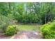Green backyard with a stone path leading into the woods at 510 Covington Cv, Alpharetta, GA 30022