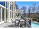 Covered balcony with an outdoor seating overlooking the pool and woodsy landscape at 510 Covington Cv, Alpharetta, GA 30022