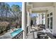 Balcony with an outdoor fireplace overlooking the pool and wooded backyard at 510 Covington Cv, Alpharetta, GA 30022