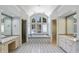 Bright primary bathroom with soaking tub under large window, tiled floors and double vanity at 510 Covington Cv, Alpharetta, GA 30022