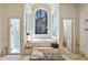 Elegant bathroom with a soaking tub beneath an arched window and separate glass-enclosed shower at 510 Covington Cv, Alpharetta, GA 30022