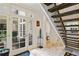 Bright entryway with stone floors, French doors, and a view of the staircase and kitchen at 510 Covington Cv, Alpharetta, GA 30022
