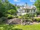 Expansive home with lush landscaping, stone steps, and large windows at 510 Covington Cv, Alpharetta, GA 30022