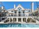 Elegant home exterior with balconies, a large backyard pool, and pristine landscaping offers luxurious outdoor living at 510 Covington Cv, Alpharetta, GA 30022