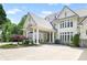 Grand front exterior with a porte cochere and meticulously landscaped yard at 510 Covington Cv, Alpharetta, GA 30022