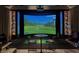 Indoor golf simulator featuring a projector screen, comfortable seating, and custom display shelves at 510 Covington Cv, Alpharetta, GA 30022