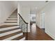 Hallway with hardwood floors, a staircase with wood railing, and entryway to a living room at 510 Covington Cv, Alpharetta, GA 30022