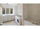 Bright laundry room with white cabinets, stone countertops, and a walk-in shower at 510 Covington Cv, Alpharetta, GA 30022