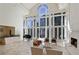 Open living room with floor-to-ceiling windows, wet bar, a grand piano, and fireplace at 510 Covington Cv, Alpharetta, GA 30022