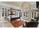 Spacious main bedroom features a canopy bed, fireplace, sitting area, and access to a private balcony with lush views at 510 Covington Cv, Alpharetta, GA 30022